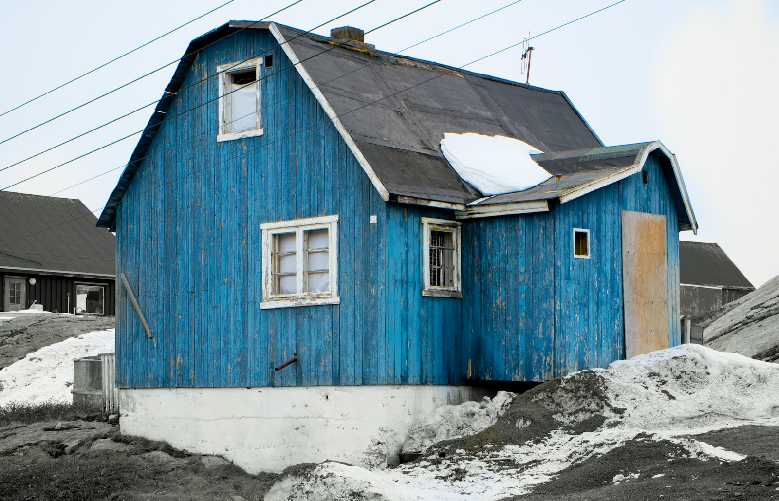 blue and white wooden house on white snow covered ground during daytime